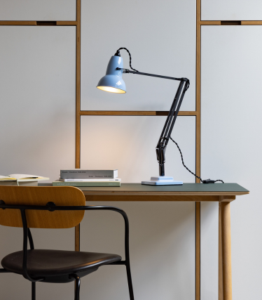 Vaaleansininen Anglepoise-pöytävalaisin puisella pöydällä tuolin vieressä